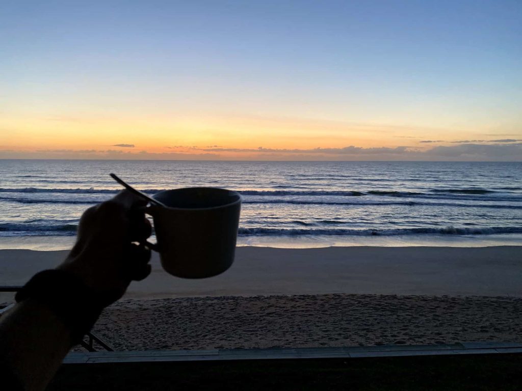 Coffee mug and sunrise in St Augustine, Florida beach