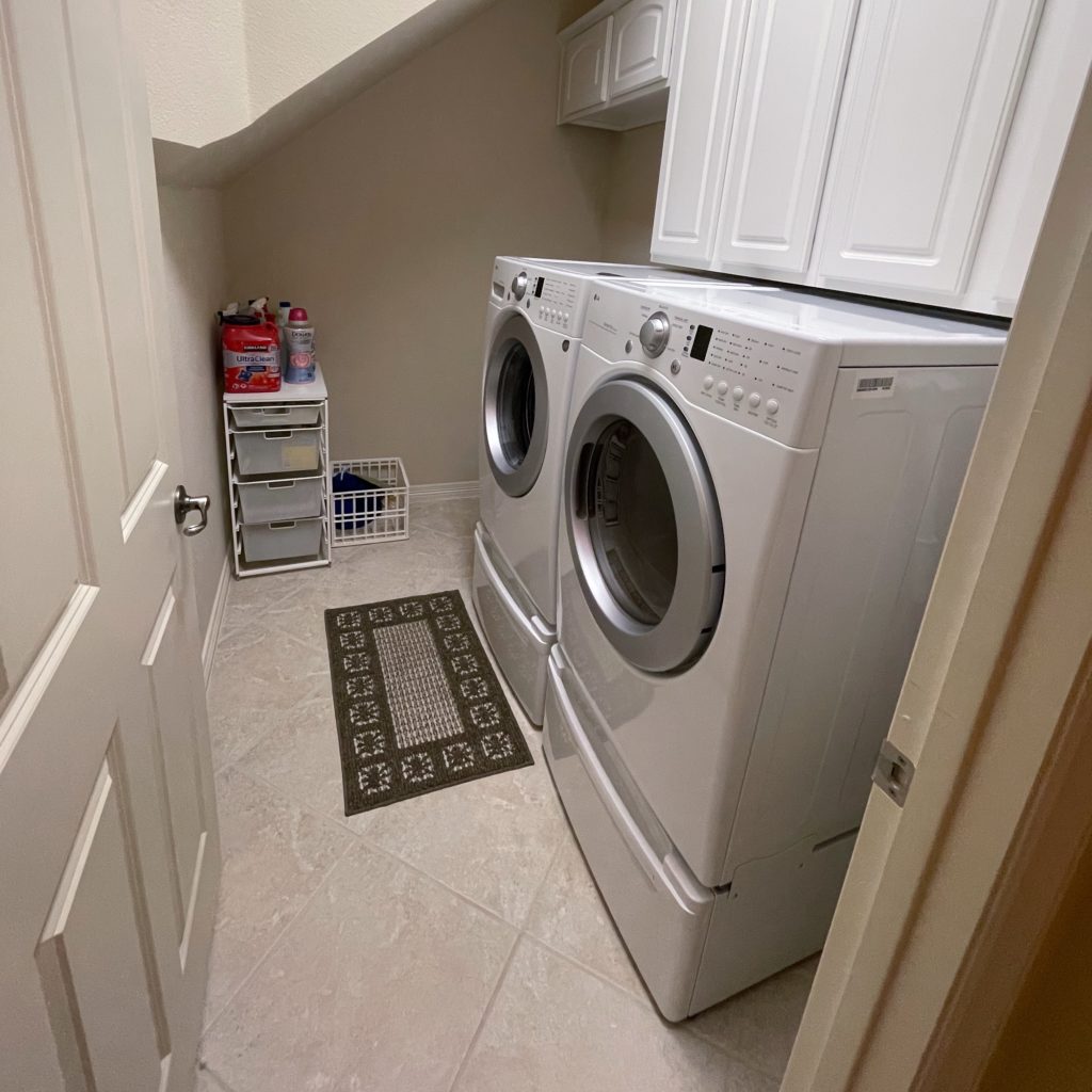 Wide angle shot of laundry room with washer and dryer in Frisco Texas that a professional organizer helped me tidy up