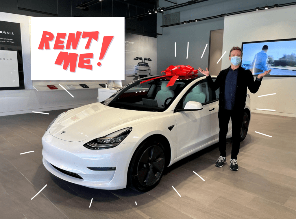Tesla Model 3 for rent, with a white car and white sign saying Rent Me and me standing next to it