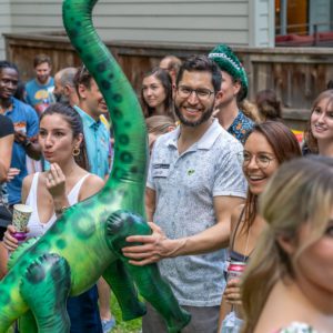 A man named David Shapiro holding an inflatable brontosaurus dinosaur
