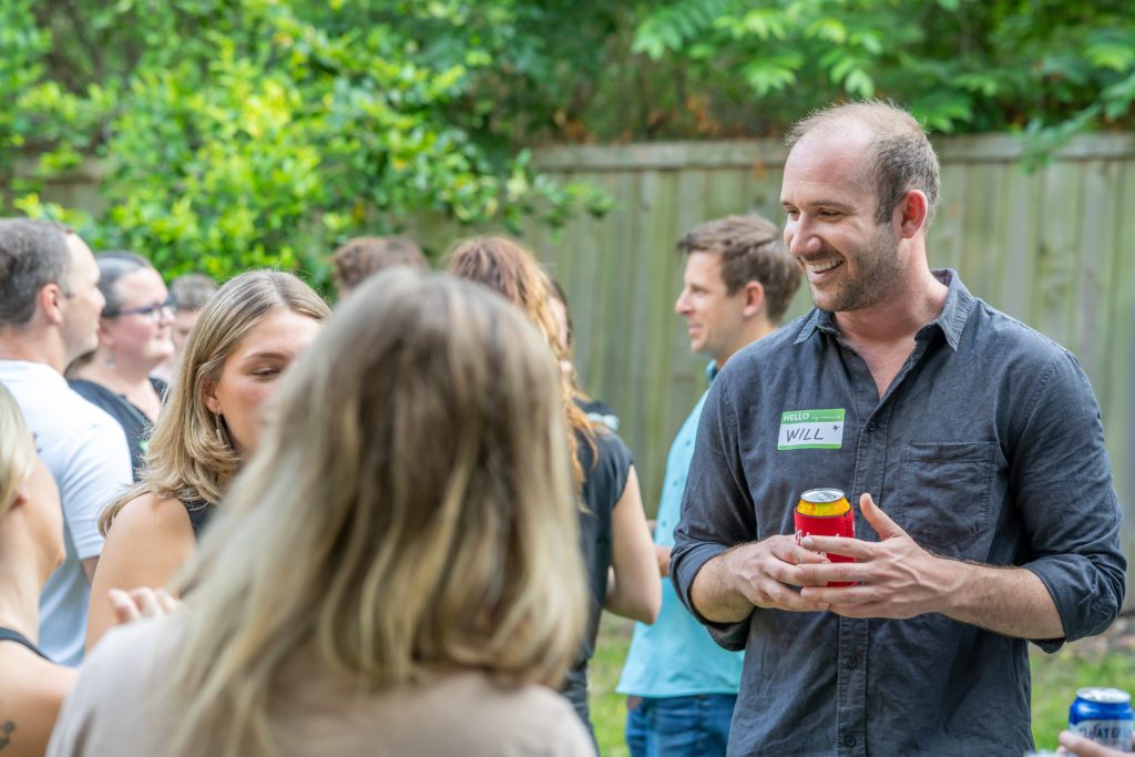 man wearing a name tag at a party, standing outside
