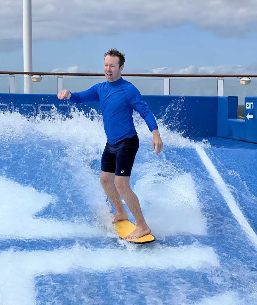 man standing on a Flowrider surf board on the back of a cruise ship