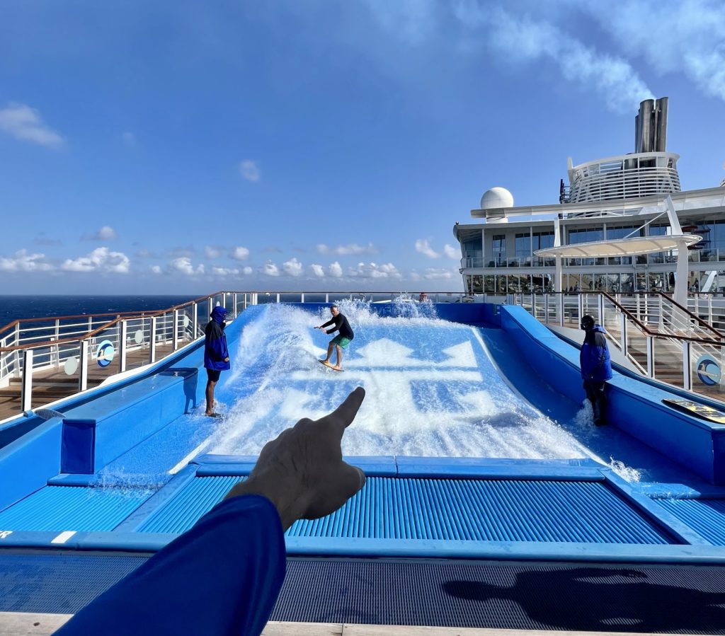finger pointing at a Flowrider surf machine on a cruise ship