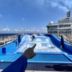 finger pointing at a Flowrider surf machine on a cruise ship