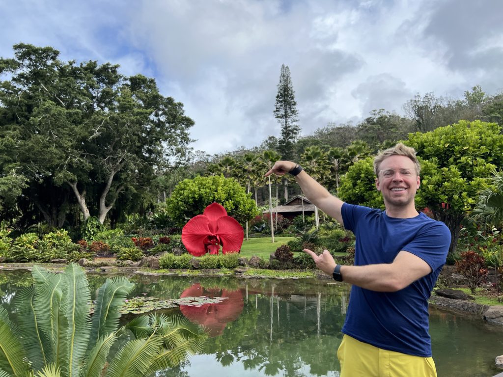 Man standing outside and pointing to a large sculpture on the Sensei Lanai grounds