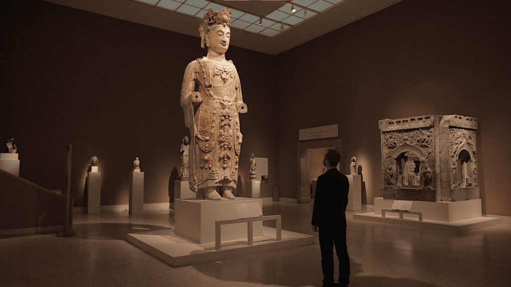 man staring up the giant statue called Bodhisattva